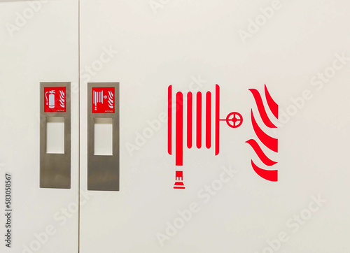 Fire hoses packed inside of red emergency box at the wall