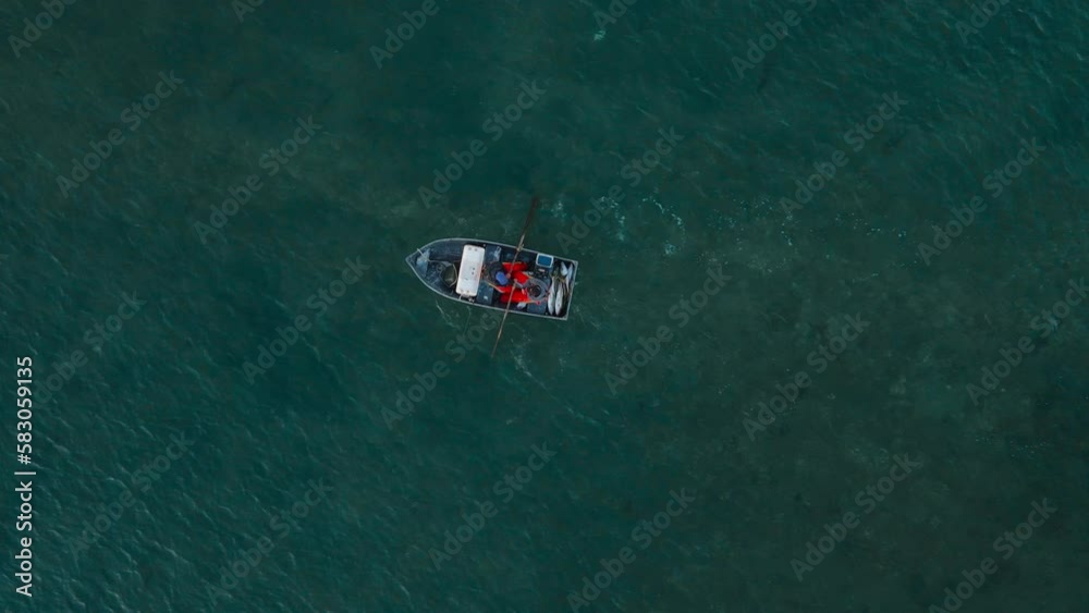birdseye view of fishermen rowing boat against outgoing tide birdseye view of fishermen rowing boat against outgoing tide