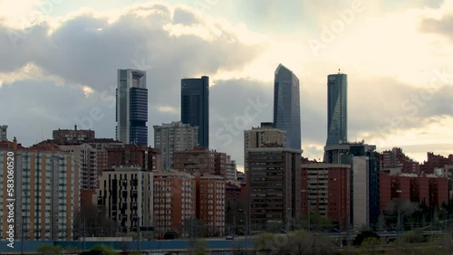 Time lapse of the four tallest skyscrapers in the city of Madrid, rising above the residential buildings, at sunset during a cloudy day. 4k resolution
