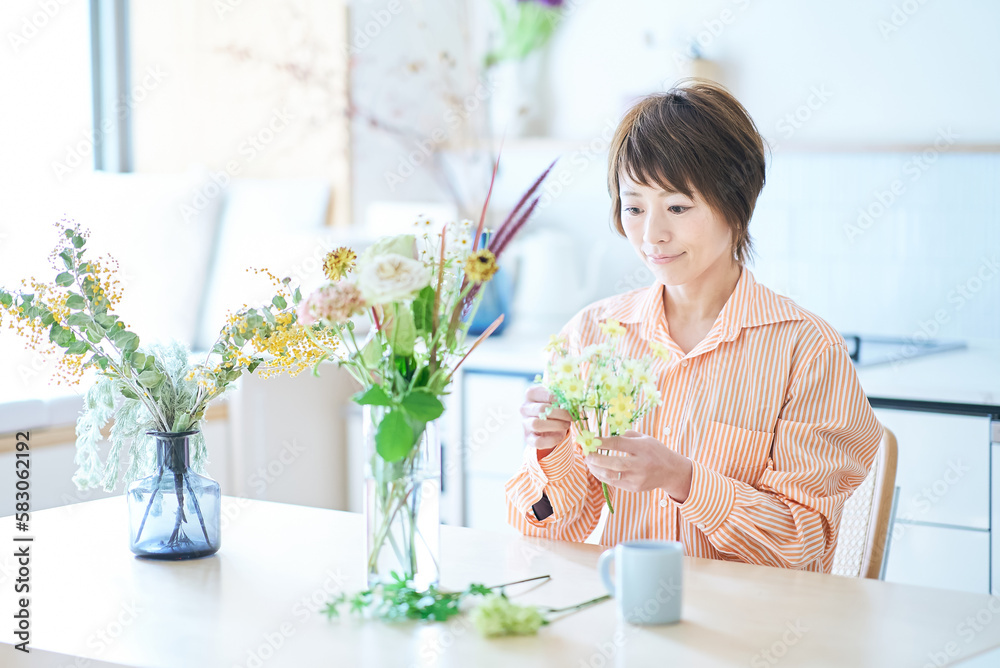部屋で花を生ける女性