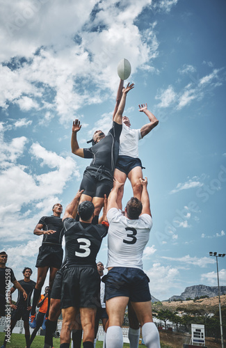 Its a battle to the top. two rugby teams competing over a ball during a line out of a rugby match outside on a filed. photo