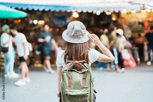 woman traveler visiting in Bangkok, Tourist with backpack and hat sightseeing in Chatuchak Weekend Market, landmark and popular attractions in Bangkok, Thailand. Travel in Southeast Asia concept