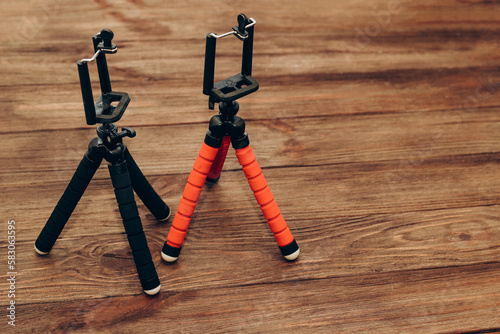 Two manual tripod monopods for a phone or a small camera on a wooden table. photo