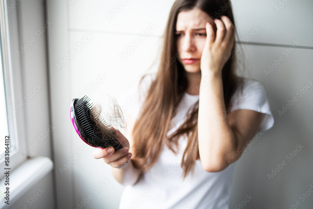 No face or unrecognizable female brunette damaged and broken hair holds a comb in her fallen hair. Concept: vitamin deficiency, hair disease, allopathy, hair loss, stress, problem No face or unrecognizable female brunette damaged and broken hair holds a comb in her fallen hair. Concept: vitamin deficiency, hair disease, allopathy, hair loss, stress, problem