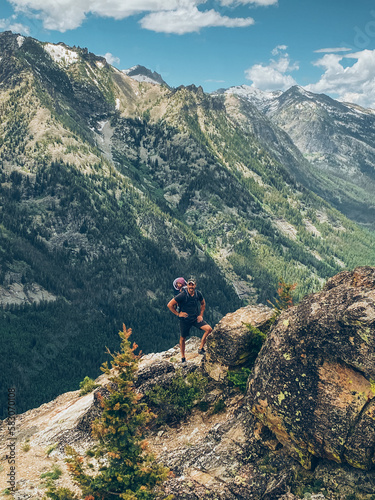 hiker with a baby in a backpack at the top of a mountain © kristineldridge