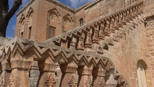 The camera sees the magnificent building of the Mor Behnam Church, one of the most important church of Mardin, and the magnificent stone staircase in front of it, tilting it from the bottom up. photo