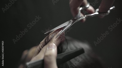 Closeup Of A Hairdresser Combing And Cutting A Mans Hair With Sciccors photo