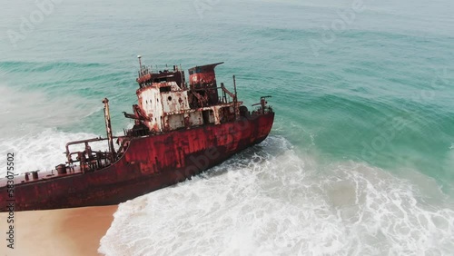 waves crashing into the bridge of an abandoned shipwreck of an oil tanker on the West African coast photo