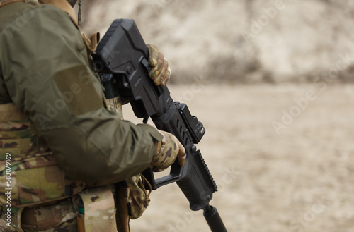 Ukrainian soldier equipped with modern bullpup assault rifle training at the shooting range outdoor