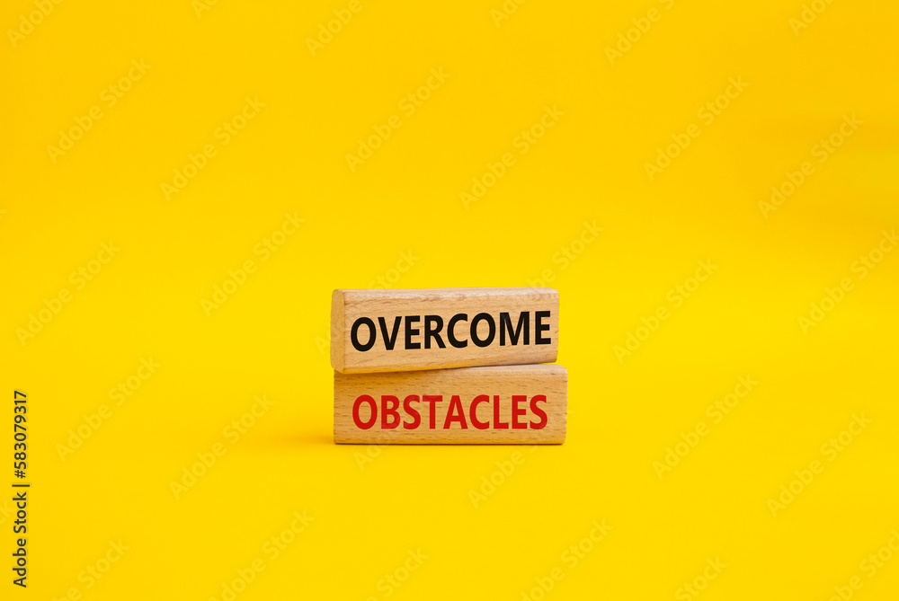 Overcome obstacles symbol. Concept words Overcome obstacles on wooden blocks. Beautiful yellow background. Business and Overcome obstacles concept. Copy space. Overcome obstacles symbol. Concept words Overcome obstacles on wooden blocks. Beautiful yellow background. Business and Overcome obstacles concept. Copy space.