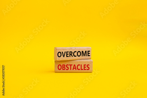 Overcome obstacles symbol. Concept words Overcome obstacles on wooden blocks. Beautiful yellow background. Business and Overcome obstacles concept. Copy space.