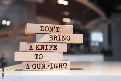 Wooden blocks with words 'Don't bring a knife to a gunfight'.