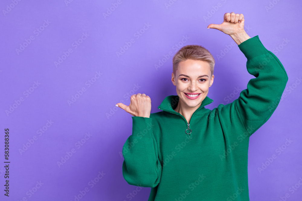 Portrait of cheerful pretty person toothy smile direct thumb fingers empty space isolated on purple color background Portrait of cheerful pretty person toothy smile direct thumb fingers empty space isolated on purple color background