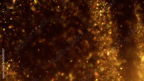 Golden glitter background in slow motion. Beautiful transition with real gold particles flying in wind on black background