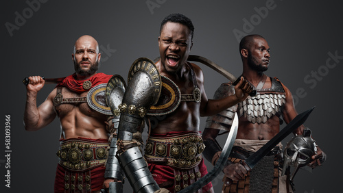 Portrait of mad warrior from ancient greece with muscular builds against grey background.