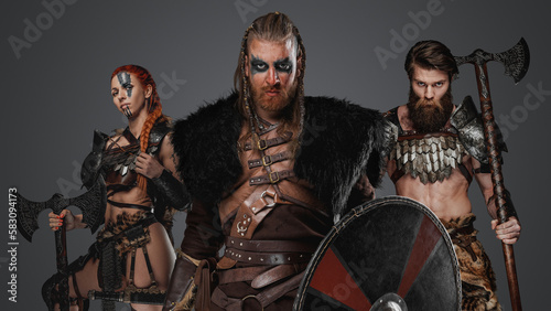 Studio shot of antique three viking with axes looking at camera.