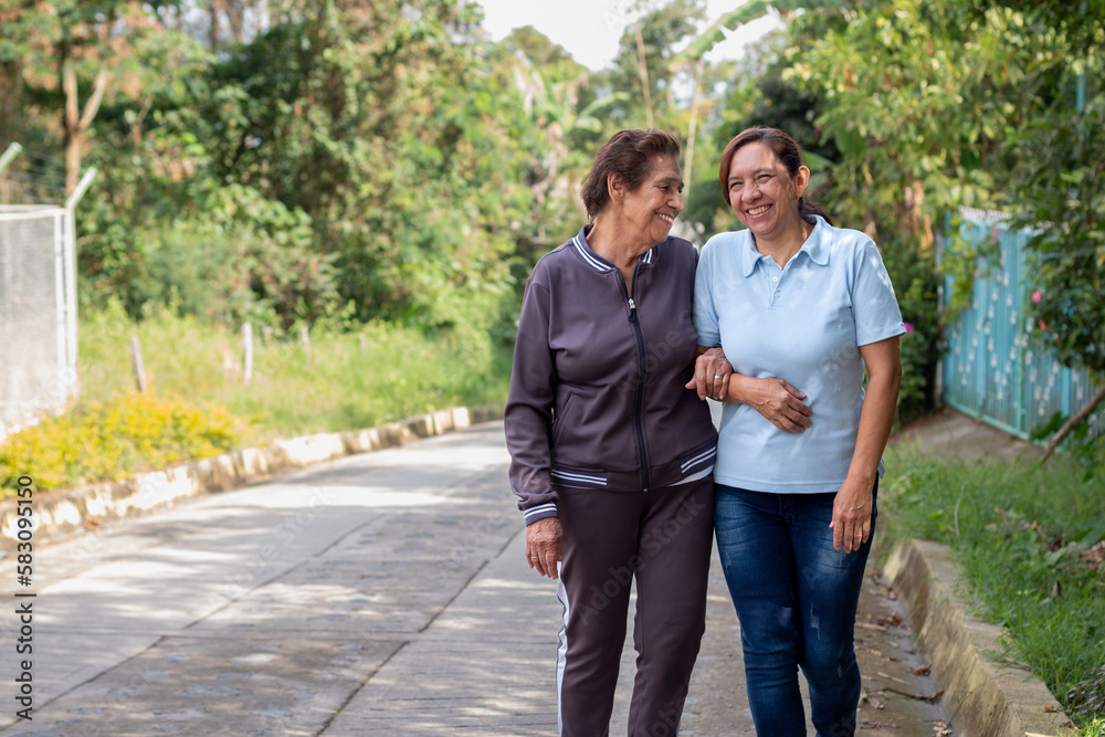 Fototapeta premium Elderly mother and daughter share a joyful moment during a morning walk in the morning.