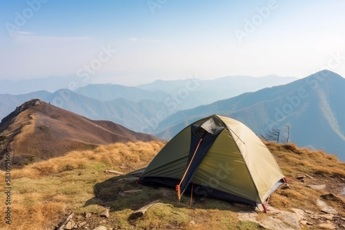 A camping tent on a mountain with wide panorama view and blue sky. Concept of travel adventure and hiking.