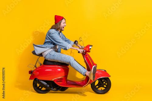 Full length photo of excited funky guy dressed jeans driving vehicle looking emtpy space isolated yellow color background © deagreez