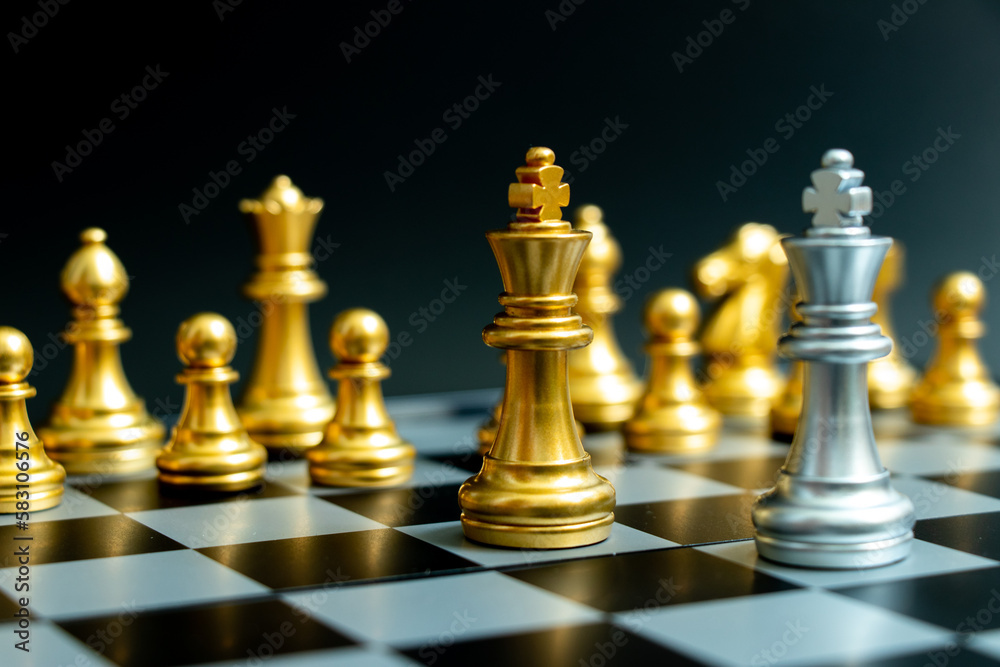 Silver king in chess game face with gold king with the another gold team behind on black background (Concept for company strategy, business victory or decision) Silver king in chess game face with gold king with the another gold team behind on black background (Concept for company strategy, business victory or decision)
