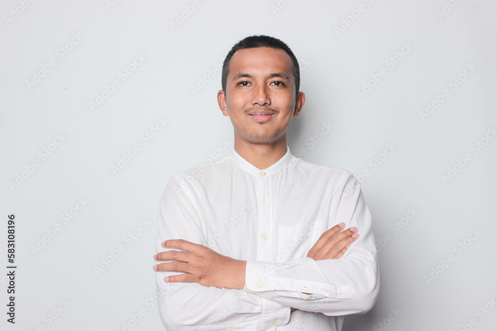Portrait of confident smiling Asian young man wearing white shirt standing with arms folded isolated on white background. Portrait of confident smiling Asian young man wearing white shirt standing with arms folded isolated on white background.