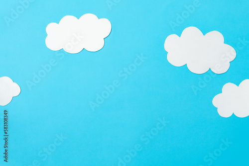 Paper clouds on blue background, flat lay, top view