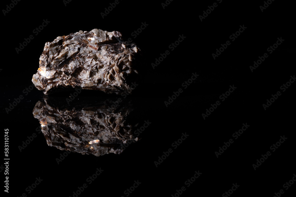 Astrophyllite mineral close-up on a black background. Astrophyllite mineral close-up on a black background.