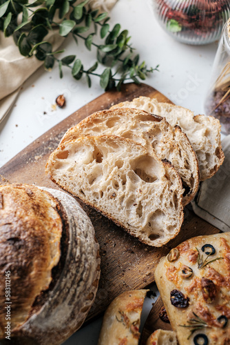 Artisan Batard Sourdough healthy Bread with leaf scoring. Open crumb high hydration Sourdough bread set on white table. © Tavan