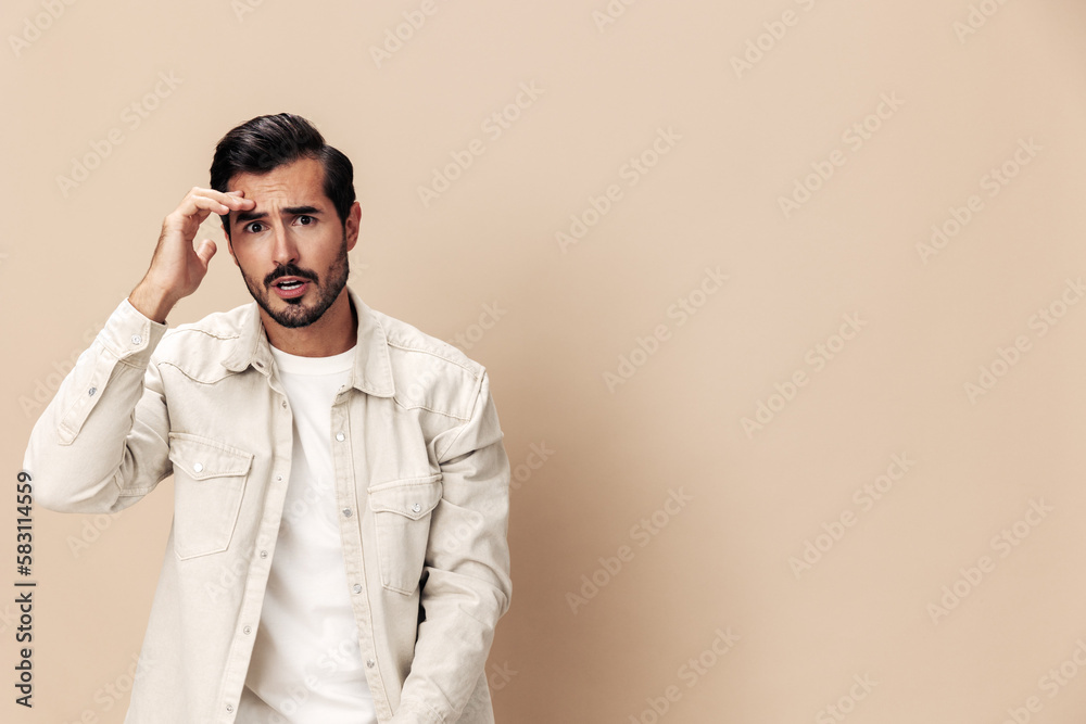 Portrait of a stylish man dissatisfied and angry screaming on a beige background in a white t-shirt looking at the camera, fashionable clothing style, copy space, space for text Portrait of a stylish man dissatisfied and angry screaming on a beige background in a white t-shirt looking at the camera, fashionable clothing style, copy space, space for text