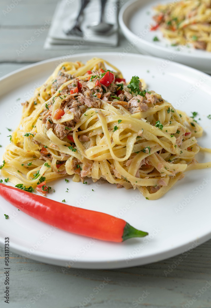 Pasta with tuna, garlic, chili, olive oil and parsley. Traditional italian cuisine Noodles aglio e olio on plate Pasta with tuna, garlic, chili, olive oil and parsley. Traditional italian cuisine Noodles aglio e olio on plate