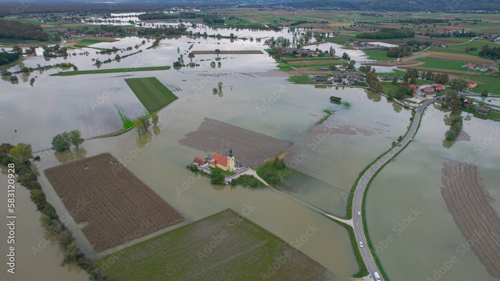 AERIAL: Church on a dry island in the middle of large area of flooded fields