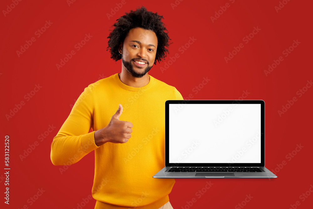 Happy business man student standing isolated on red background pointing at laptop mockup white screen advertising online learning, education training and webinars, studying video courses