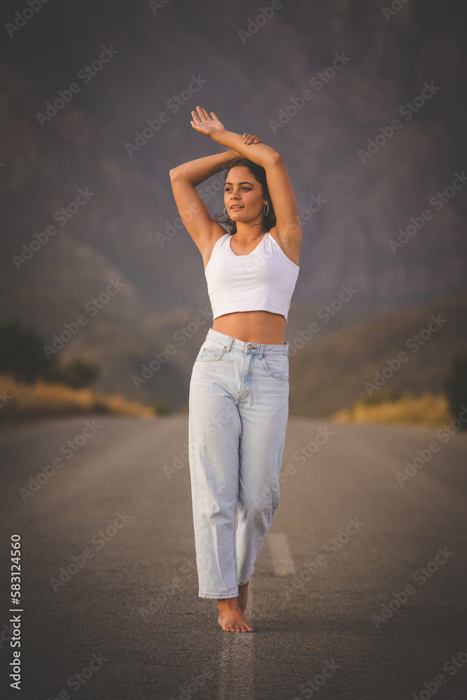Obraz premium Young Fashionable Woman Posing on a Deserted Road