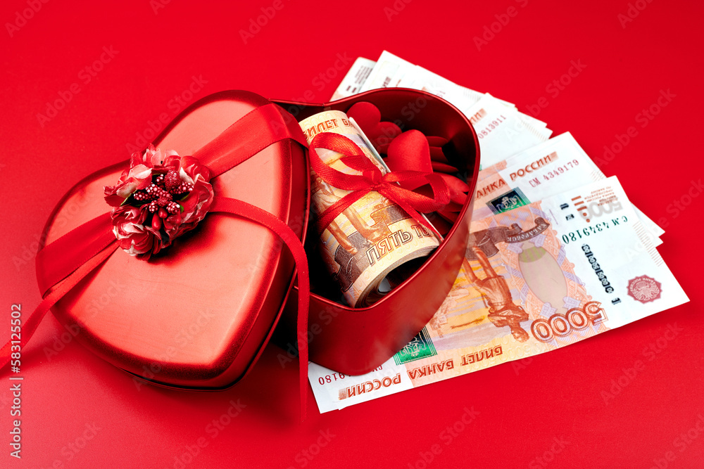 Russian rubles on red background, bundle of five thousand banknotes with red ribbon in heart box, money gift concept Russian rubles on red background, bundle of five thousand banknotes with red ribbon in heart box, money gift concept