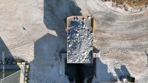 Huge dumper working at a limestone quarry., transferring the material into the crusher.