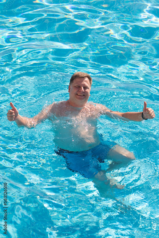 Happy man swimming pool with his thumbs up.