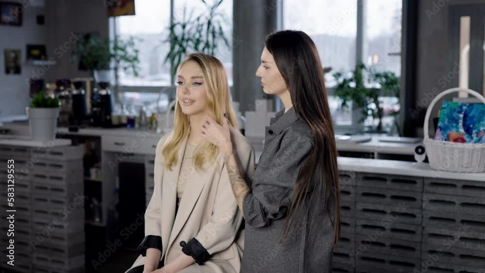 Two women in a beauty salon discuss the result of the work of a makeup artist and hairdresser Two women in a beauty salon discuss the result of the work of a makeup artist and hairdresser