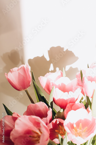 Fototapeta Naklejka Na Ścianę i Meble -  Gently pink bouquet of tulips in a white vase. Spring background with a bouquet of flowers. Front view