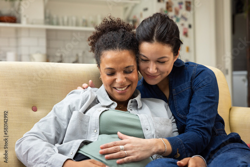 Lesbian couple pregnant with their first child at home photo