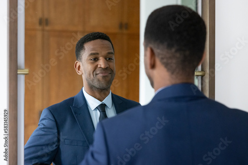 African American businessman getting ready for a new job looking in a mirror photo