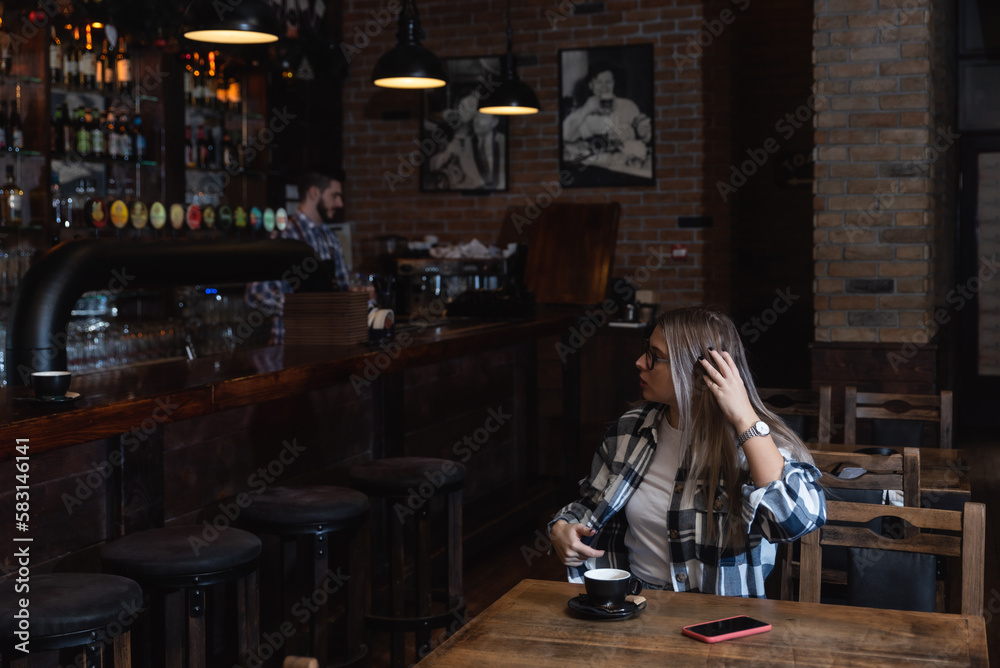 Two Diverse Entrepreneurs Have a Team Meeting in Their Stylish Coffee Shop. Barista and Cafe Owner Discuss Work Schedule and Menu on Mobile or Computer. Young Female and Male Restaurant Employees