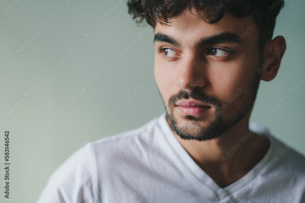 Close-up portrait of a serious handsome man looking away standing isolated on studio background. People lifestyle portrait. Closeup portrait. Young male model Close-up portrait of a serious handsome man looking away standing isolated on studio background. People lifestyle portrait. Closeup portrait. Young male model