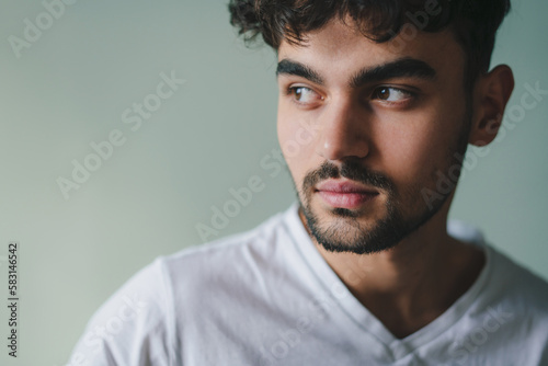 Close-up portrait of a serious handsome man looking away standing isolated on studio background. People lifestyle portrait. Closeup portrait. Young male model