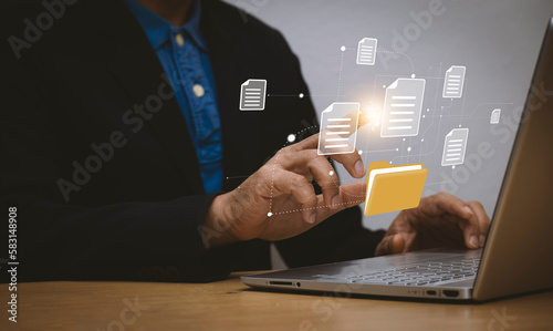 Document management system concept is installing by IT consultant working on laptop computer in office. Software for archiving, searching and managing corporate files and data.