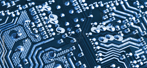 Blue toned panoramic photo of a printed circuit boards