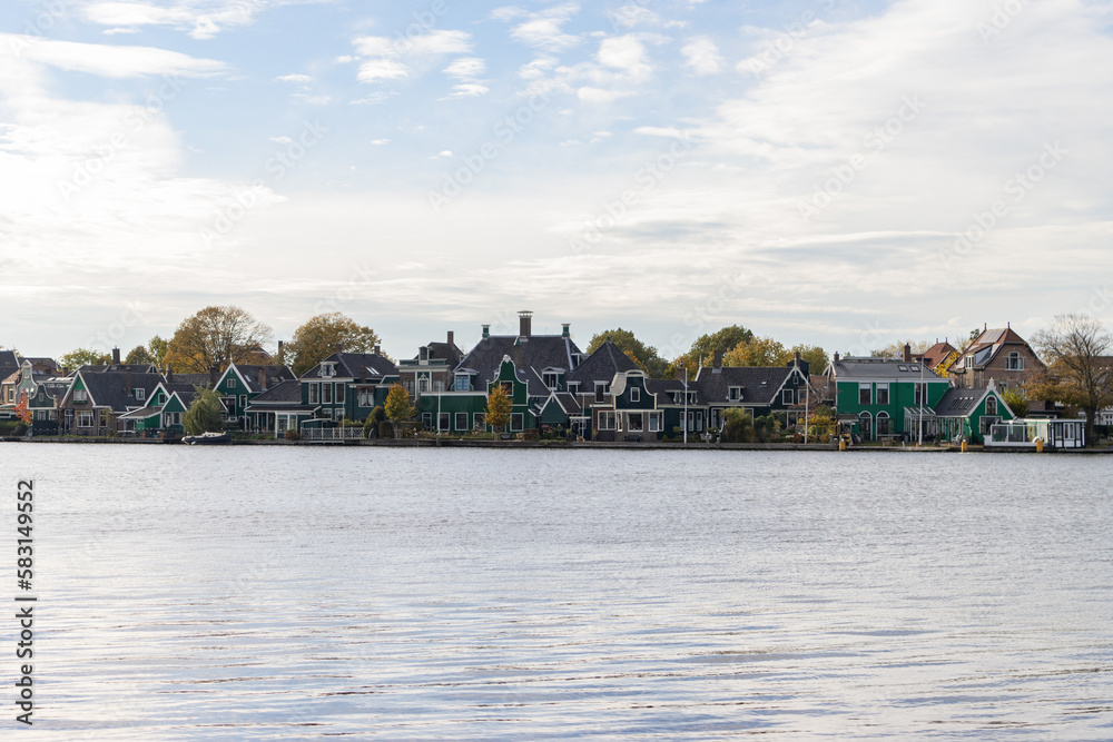 Naklejka premium Traditional Green Buildings along the Zaan River in Zaandijk Netherlands