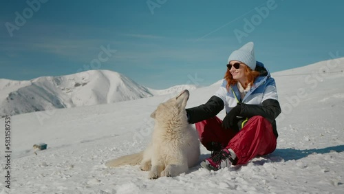 Woman with her dog living carefree in the mountains. Tourist ecounting a dog while resting on her walking path back. photo