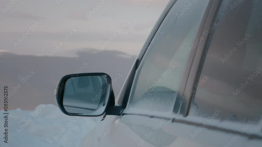Car wing mirror covered in snow and ice during bad weather in winter. Car wing mirror covered in snow and ice during bad weather in winter.