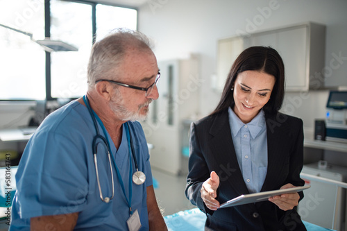 Young pharmaceutic seller explaining something to doctor in hospital. photo