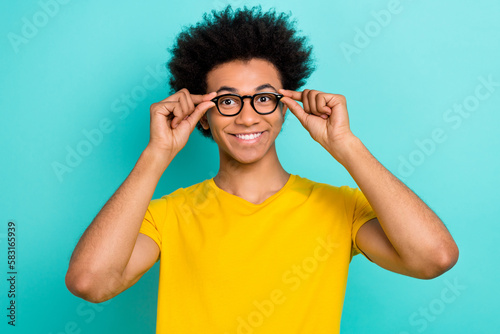 Portrait of cheerful smart young man toothy smile hands touch glasses isolated on turquoise color background